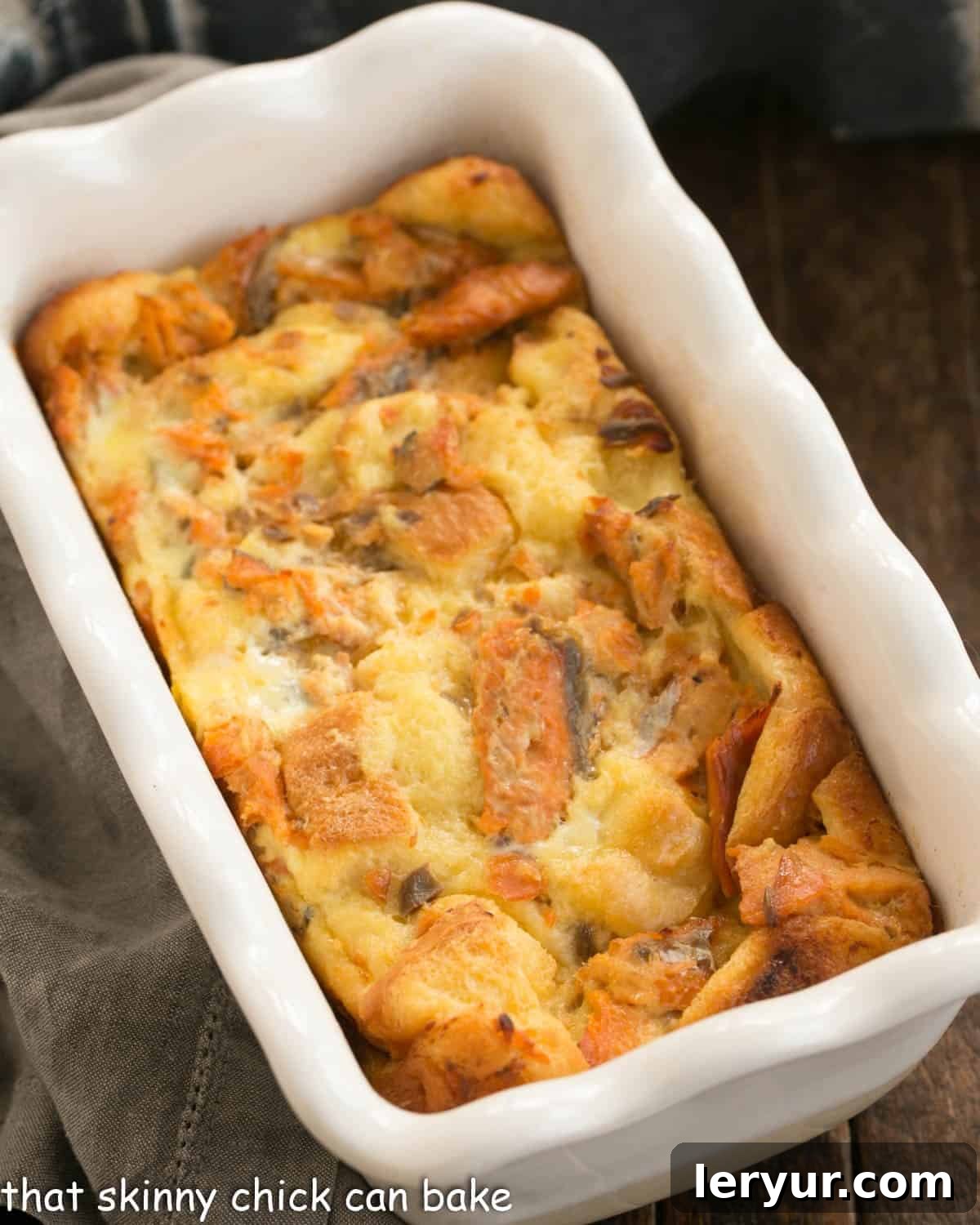 An inviting overhead close-up of a rustic, golden-brown salmon loaf, freshly baked and nestled within a charming ceramic loaf pan, ready to be sliced and served.