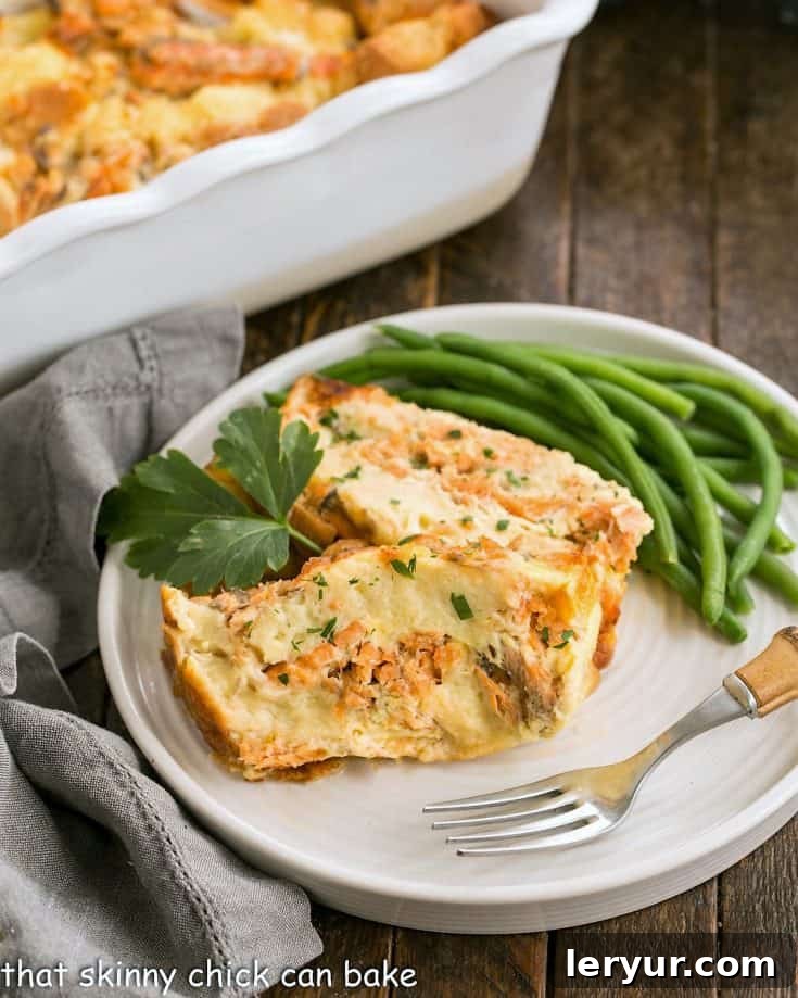 Two perfectly sliced portions of baked salmon loaf are artfully arranged on a pristine white plate, accompanied by a vibrant serving of steamed green beans, ready to be enjoyed.