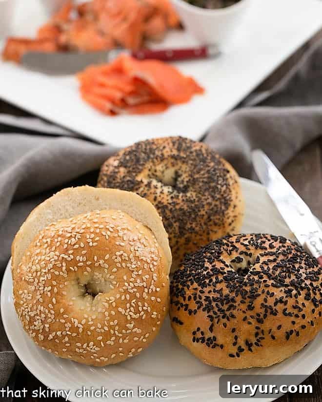 A beautiful spread of homemade bagels with a tray of fresh smoked salmon, various cream cheeses, capers, red onion, and lemon slices.