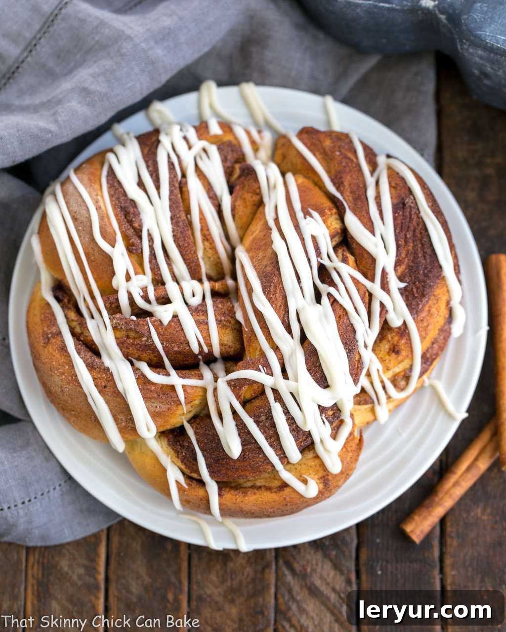 A beautifully baked Cinnamon Twist Bread on a pristine white plate, showcasing its intricate swirls and golden-brown crust.