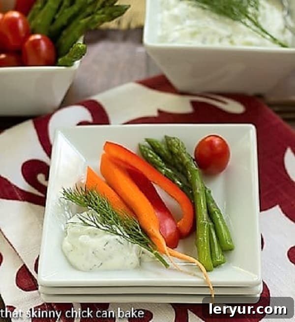 Tzatziki on a stack of white plates with fresh vegetables