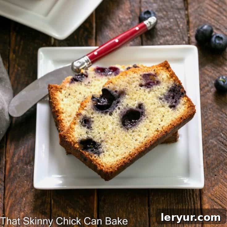 Blueberry Poppy Seed Bread slices arranged on a square white plate next to a red-handled knife.
