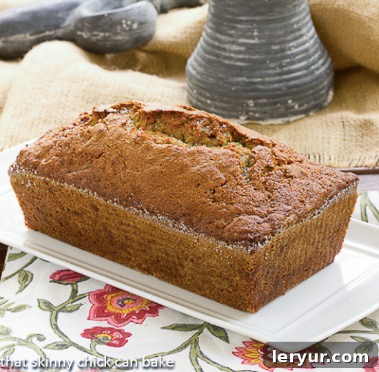 Sugar Crusted Zucchini Bread - A classic zucchini bread recipe with a sweet sugar crust A whole loaf of Sugar Crusted Zucchini Bread resting on a rectangular, ceramic serving tray, highlighting its glistening sugar crust.
