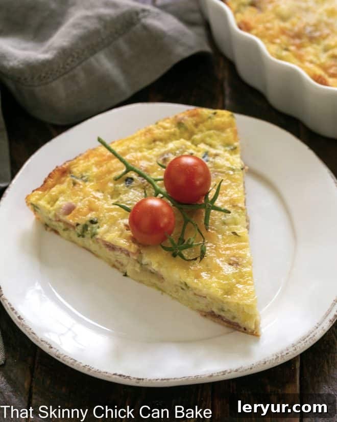 Savory Zucchini and Prosciutto Quiche 2 Slice of Zucchini Quiche with Prosciutto garnished with cherry tomatoes on a white plate, ready to be enjoyed.
