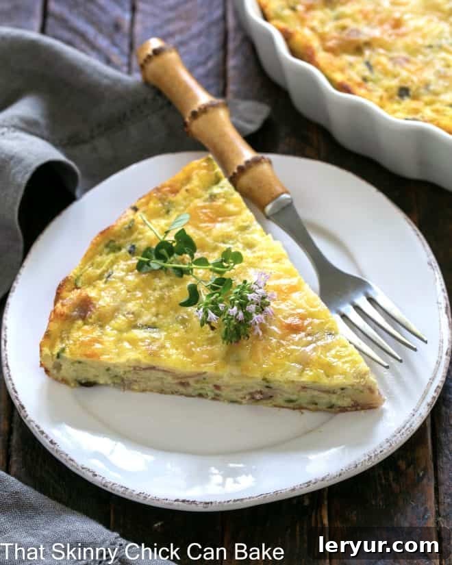 Savory Zucchini and Prosciutto Quiche 4 Slice of zucchini quiche garnished with a thyme sprig on a white plate with a bamboo fork, showcasing its gourmet appeal.