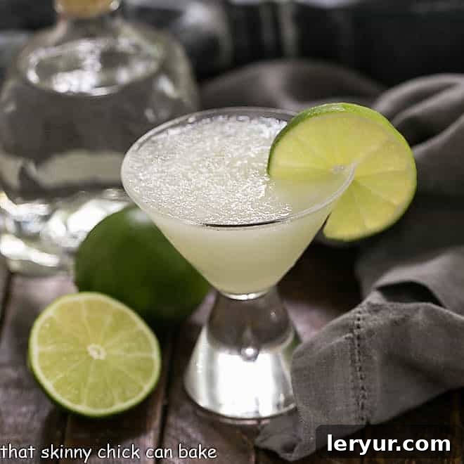 Easy 3-Ingredient Margarita in a small martini glass garnished with lime, against a bright background.