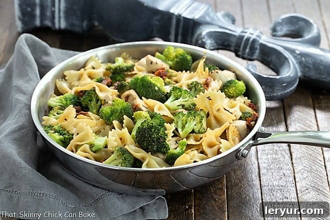 Chicken with Broccoli, Sun-dried Tomatoes and Bow Tie Pasta - An easy, flavorful weeknight meal! Chicken Broccoli Sun-dried tomato Pasta in a stainless steel frying pan, ready to be served.