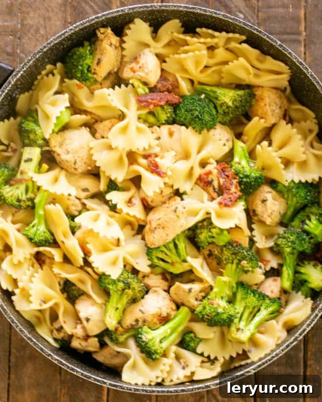 Vibrant Sun-Dried Tomato Chicken Broccoli Pasta 5 Chicken in skillet with broccoli and pasta.