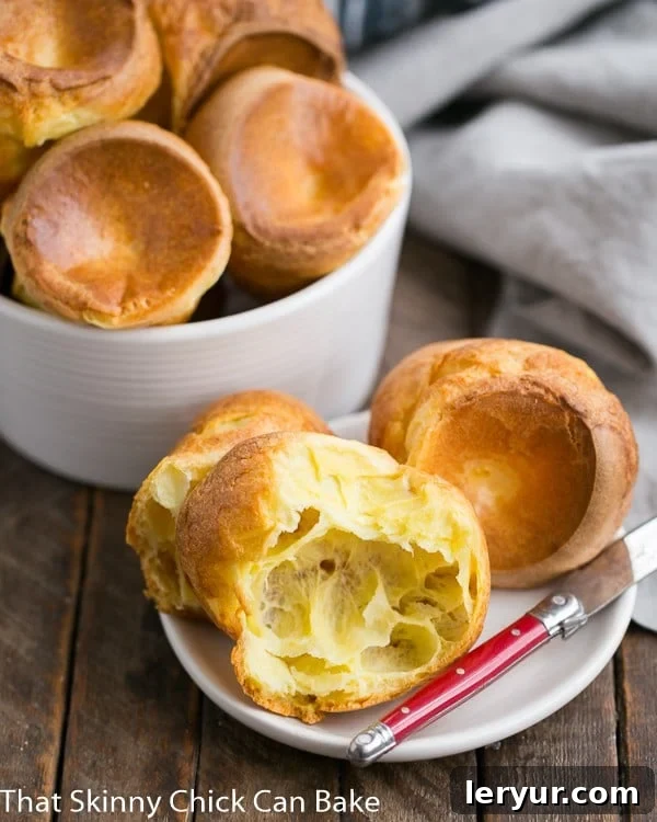 Perfect Popovers - puffed, eggy muffins that are a marvelous addition to your dinner menu, offering a delightful texture and taste. Freshly baked perfect popovers on a white plate with a small red-handled knife, ready to be served.