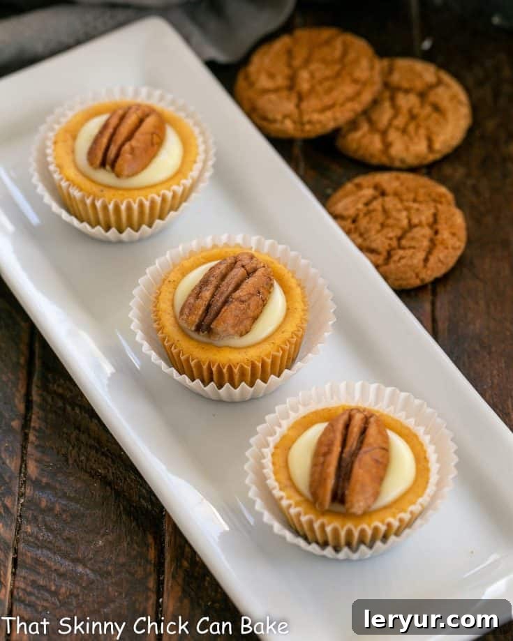 A beautifully composed image of mini pumpkin cheesecakes arranged on a crisp white ceramic tray, showcasing their perfect shape and delicate toppings.