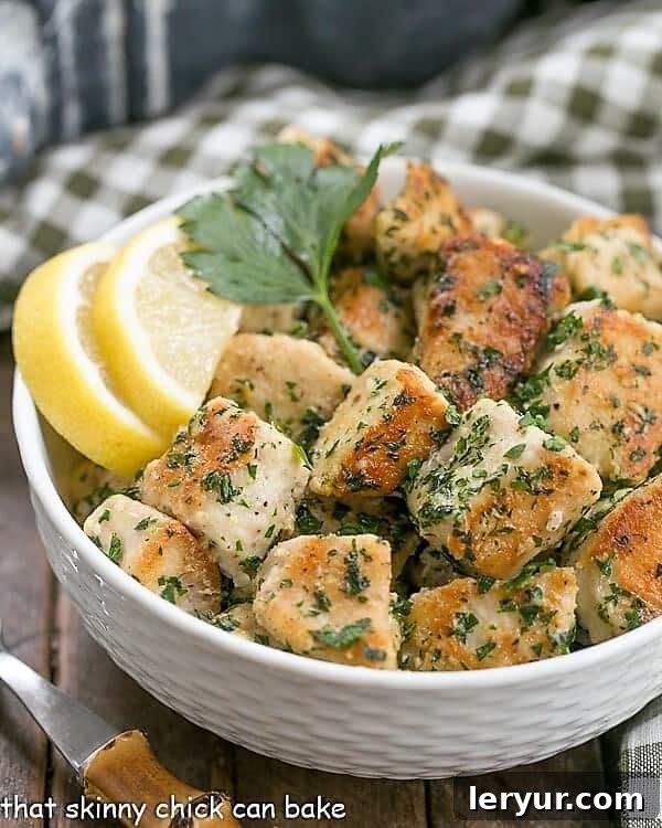 Chicken with Garlic and Parsley - Easy, delicious and flavorful with only a few ingredients and finished in less than 30 minutes! Golden brown pan-fried chicken with fresh garlic and parsley, served in a white bowl with lemon wedges.