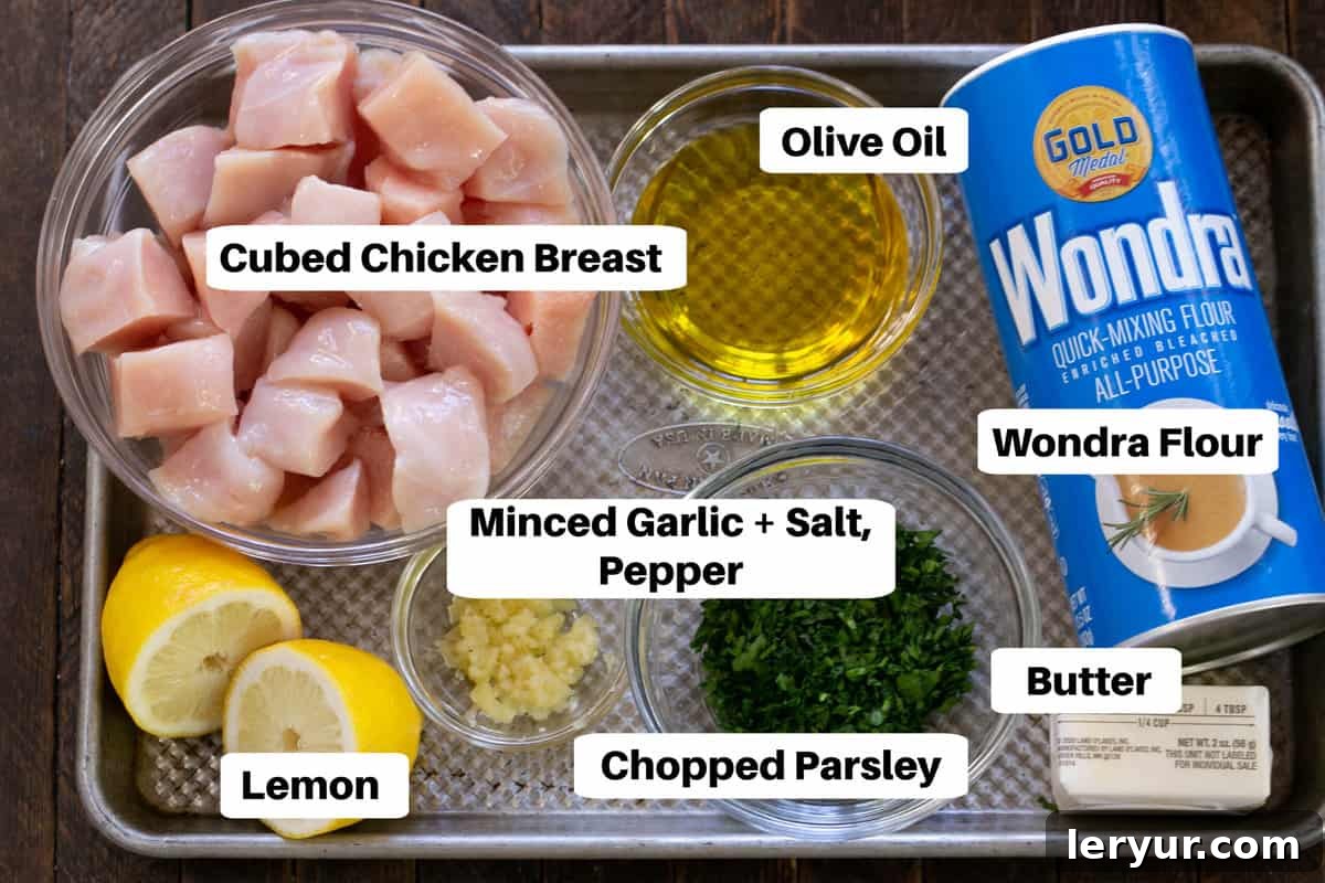 Zesty Garlic Parsley Chicken 2 Ingredients for Garlic Parsley Chicken, neatly laid out on a sheet pan with labels, including chicken, garlic, parsley, butter, flour, salt, and pepper.