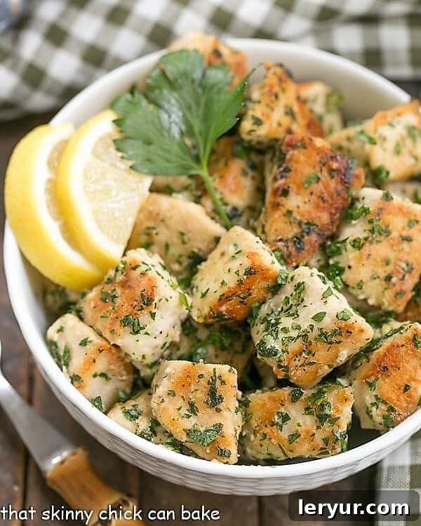 Chicken with Garlic and Parsley - Easy, delicious and flavorful with only a few ingredients and finished in less than 30 minutes! Close-up of Chicken with Garlic and Parsley with lemon slices in a white bowl, ready to serve.