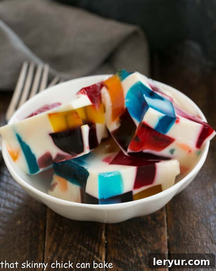 A serving of Broken Glass Jello, featuring colorful cubes in a creamy white base, elegantly presented in a small dish.