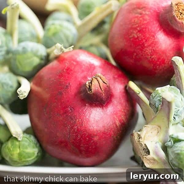 Spinach, Strawberry, Pomegranate, Feta Salad with the BEST balsamic vinaigrette! Fresh pomegranates and vibrant Brussels sprouts artfully arranged on a sheet pan, showcasing the beauty of seasonal produce.
