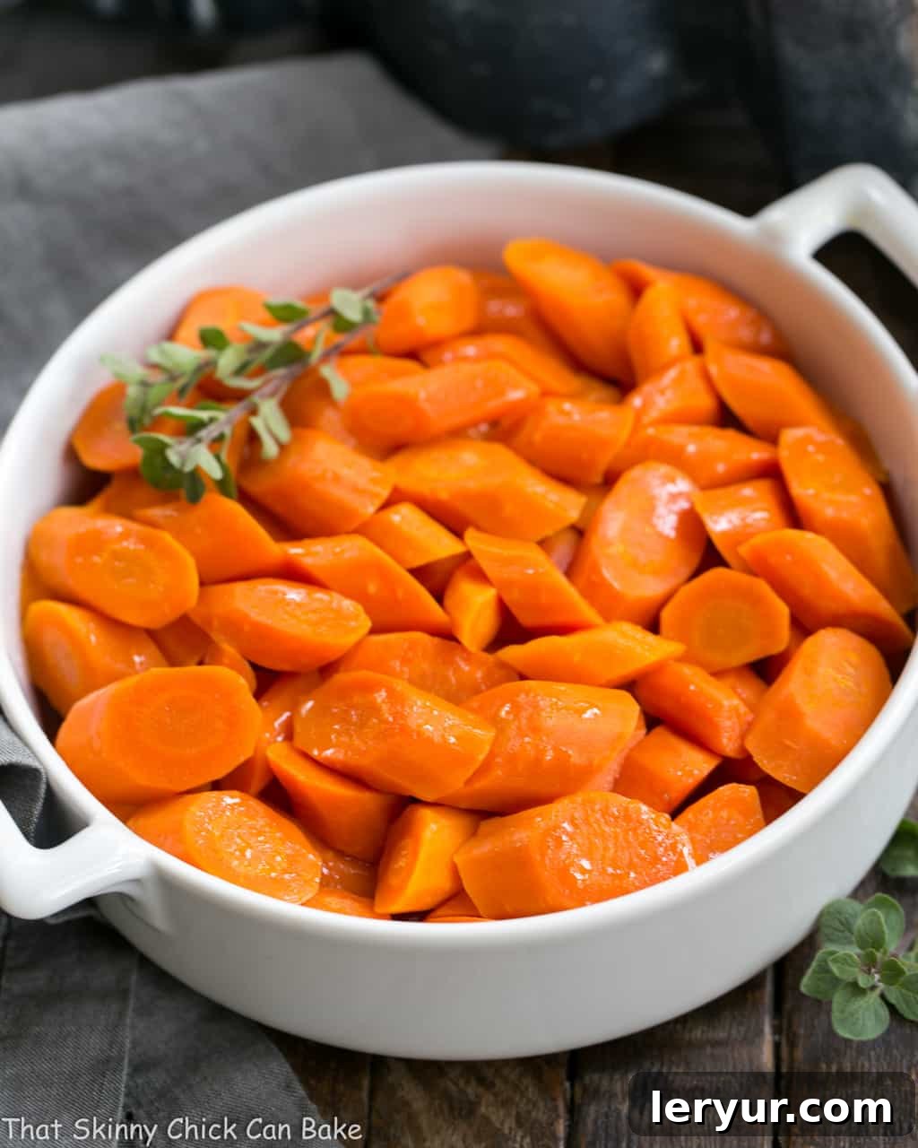Bourbon Maple Glazed Carrots - An easy way to transform carrots into a restaurant worthy side dish! Vibrantly colored Bourbon Maple Glazed Carrots served in a pristine white ceramic dish, ready to be enjoyed as a gourmet side dish.