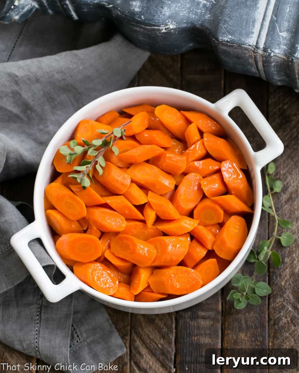 Bourbon Maple Glazed Carrots - An easy way to transform carrots into a restaurant worthy side dish! Appetizing Bourbon Maple Glazed Carrots presented in a rustic round ceramic dish, garnished with fresh green herbs.