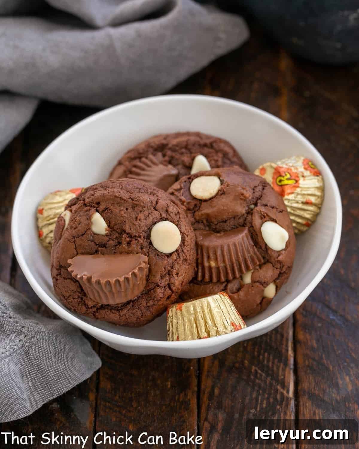Ultimate Peanut Butter Fudge Swirl Cookies 2 A bowl of freshly baked, fudgy Moose Tracks Cookies, showcasing their decadent chocolate base, melted peanut butter cups, and visible white chocolate chips.