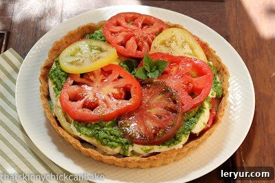 Rustic Fresh Tomato Tart - A Timeless Summer Classic A beautiful, rustic fresh tomato tart on a white plate, showcasing the simple elegance of the dish.