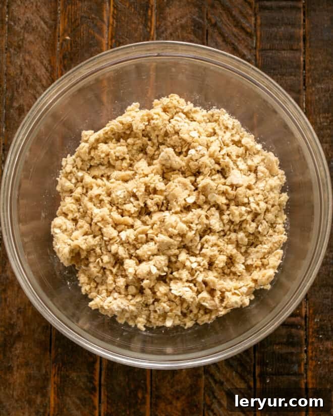 A bowl of buttery streusel crumbs, ready for use as both crust and topping for the date bars.