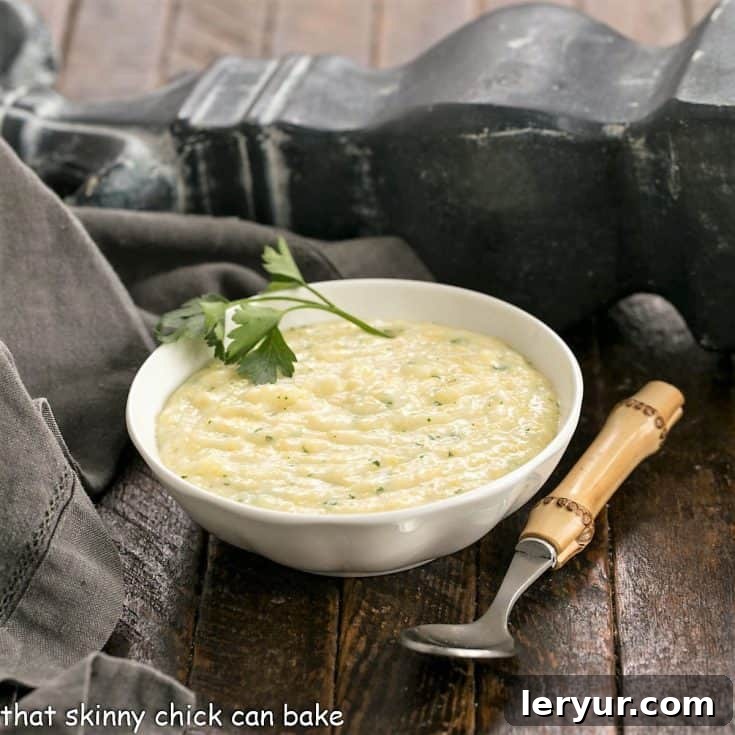Small bowl of creamy Parmesan Polenta garnished with fresh parsley next to a bamboo handle spoon.
