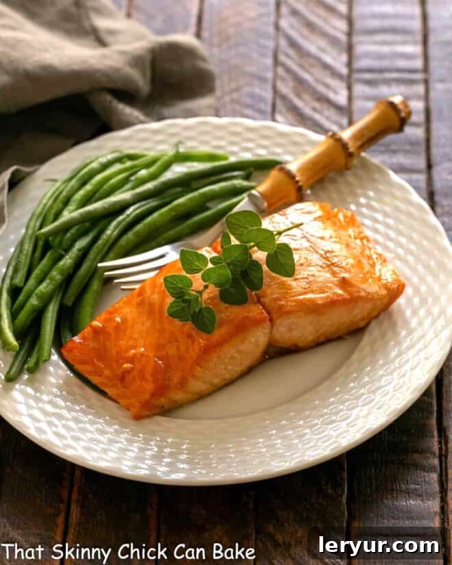 Grilled Salmon Date Night 2 Marinated salmon for two on a white plate with a fork and green beans, perfectly grilled.