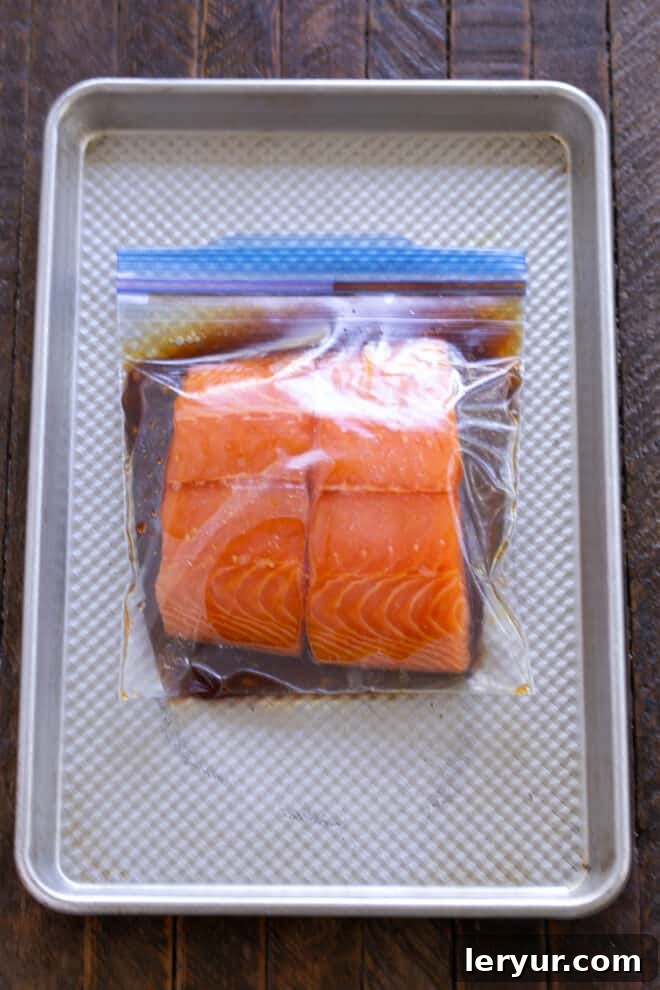Grilled Salmon Date Night 5 Salmon fillets soaking in a flavorful marinade inside a Ziploc bag, ready for refrigeration.