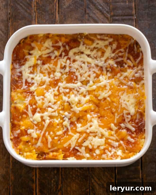 An overhead view of the golden-brown Twice Baked Potato Casserole, freshly baked and ready to be served, showing melted cheese and a hint of green onions.