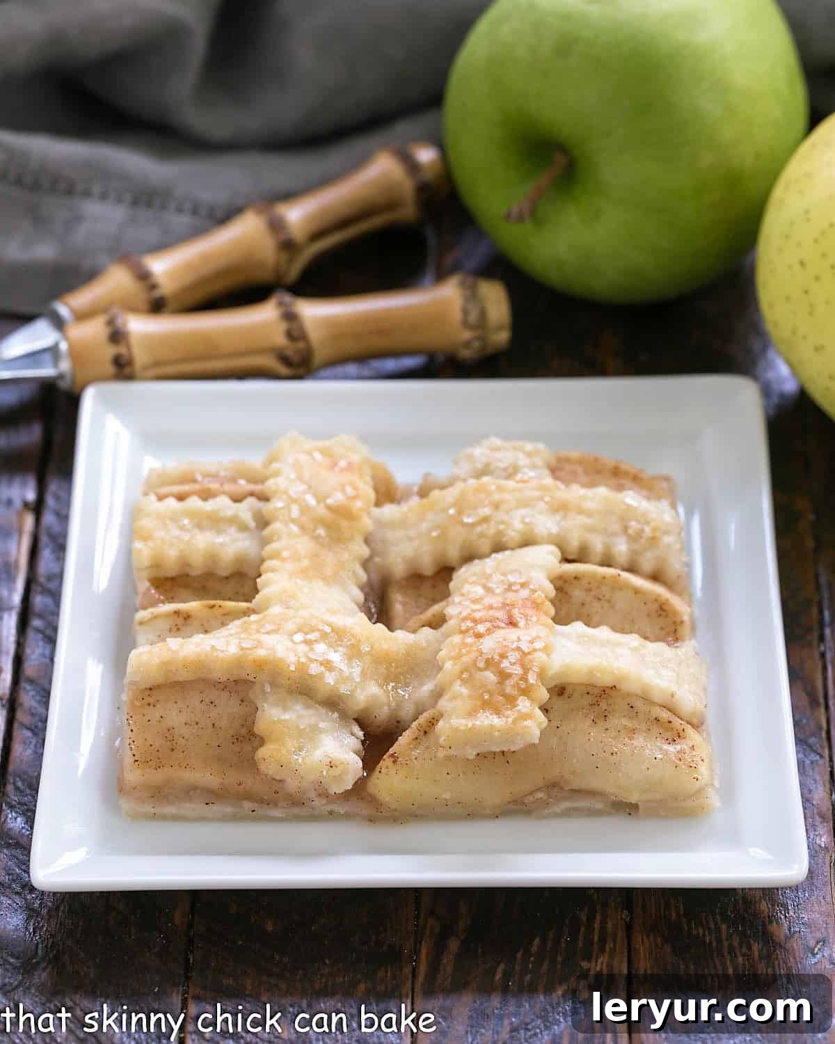 A slice of apple slab pie or apple squares on a square white plate.