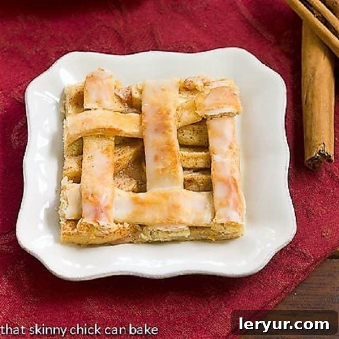 A slice of apple slab pie or apple squares on a white plate