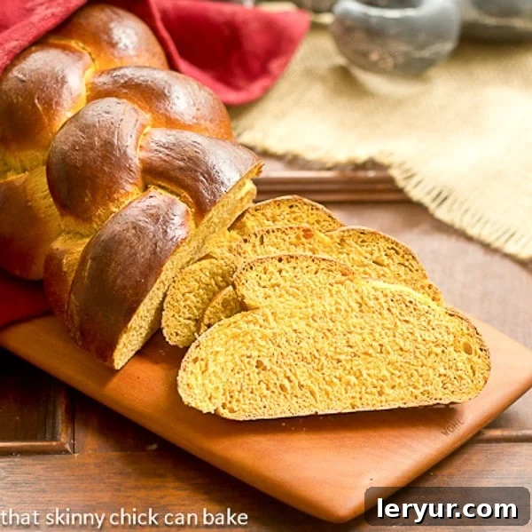Serving Ideas for Your Delicious Pumpkin Challah Perfectly sliced Pumpkin Challah bread displaying its tender crumb and subtle orange tint, resting on a clean wooden cutting board, ready for enjoyment.
