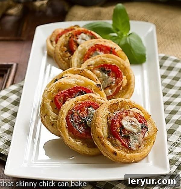 Tomato and Boursin Tartlets on a white ceramic tray, showcasing their elegant presentation and vibrant colors.
