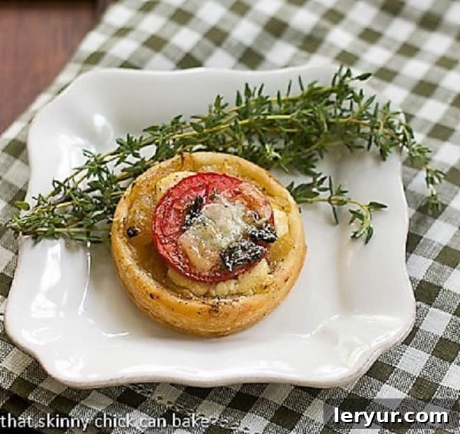 Tomato and Boursin Tartlet on a square white plate with fresh thyme, ready to be served.