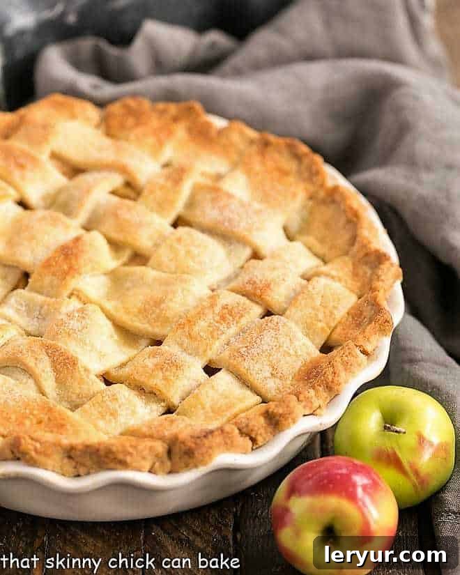 Perfect Apple Pie with a lattice crust in a ceramic pie plate. A beautifully golden-brown lattice top pie, showcasing a truly homemade and artisanal crust, promises a delightful dessert experience.