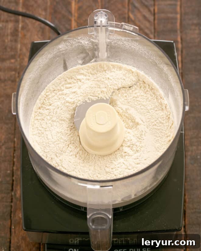 Dry ingredients (flour, salt, sugar) in a food processor bowl.