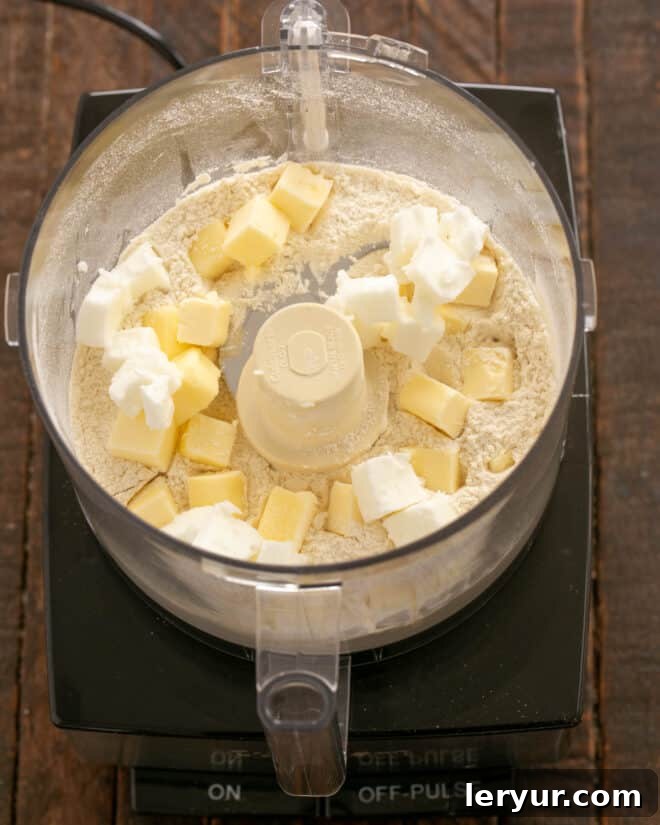 Cold butter and shortening cubes added to dry ingredients in a food processor.