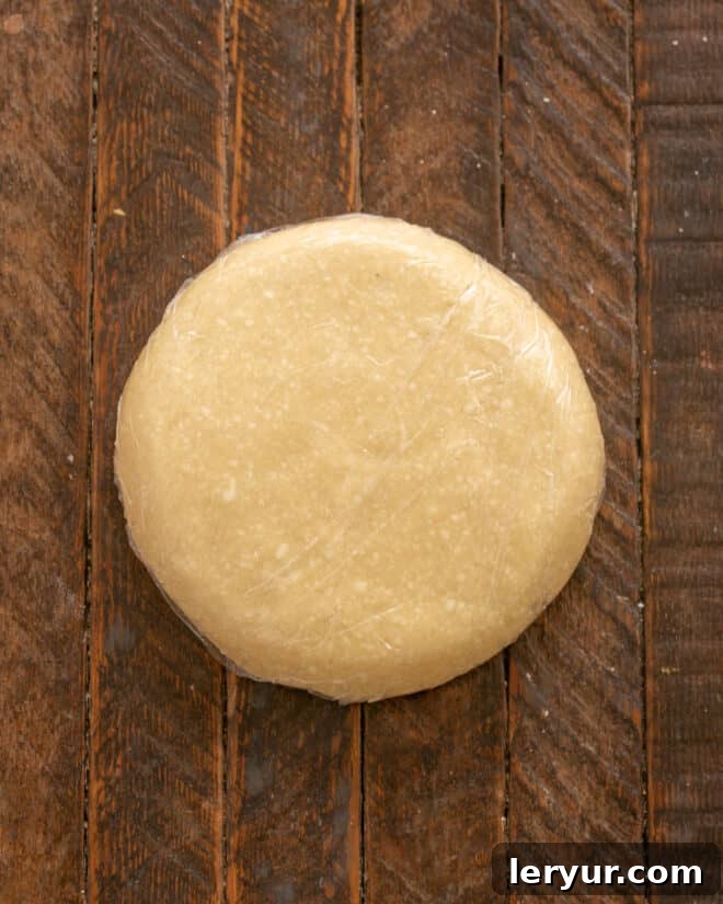 Pie dough divided into two disks and wrapped in plastic wrap.