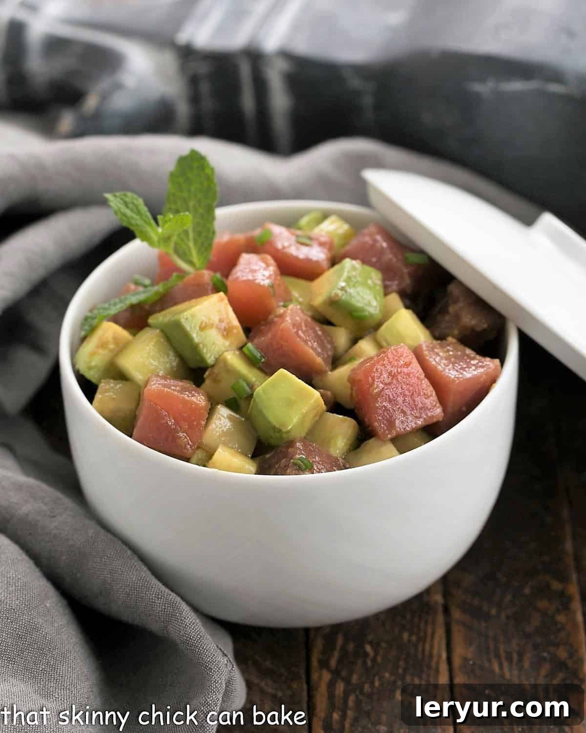 Fresh Tuna Tartare with creamy avocados, served in a stylish white ceramic bowl, ready to be enjoyed as a gourmet appetizer.