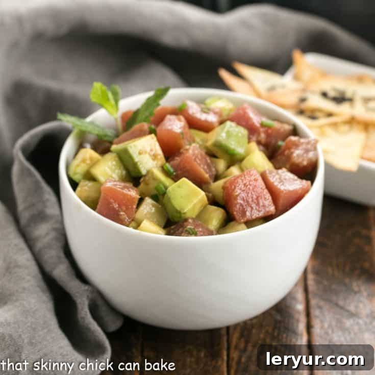 Exquisitely presented Tuna Avocado Tartare, served in a white ceramic bowl with crispy wonton chips, showcasing a perfect appetizer.
