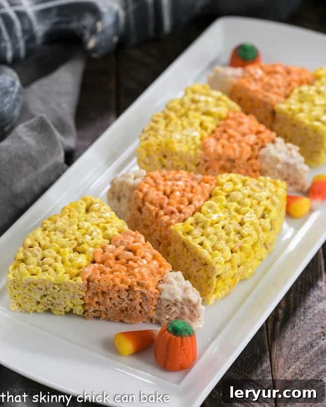 Candy Corn Rice Krispie Treats neatly arranged on a white serving tray.