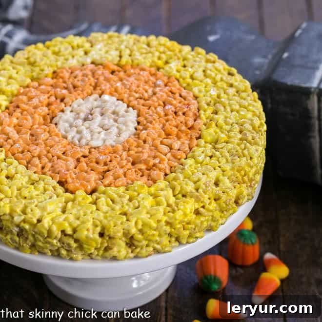 Uncut Candy Corn Rice Krispie Treats arranged beautifully on a pristine cake stand.