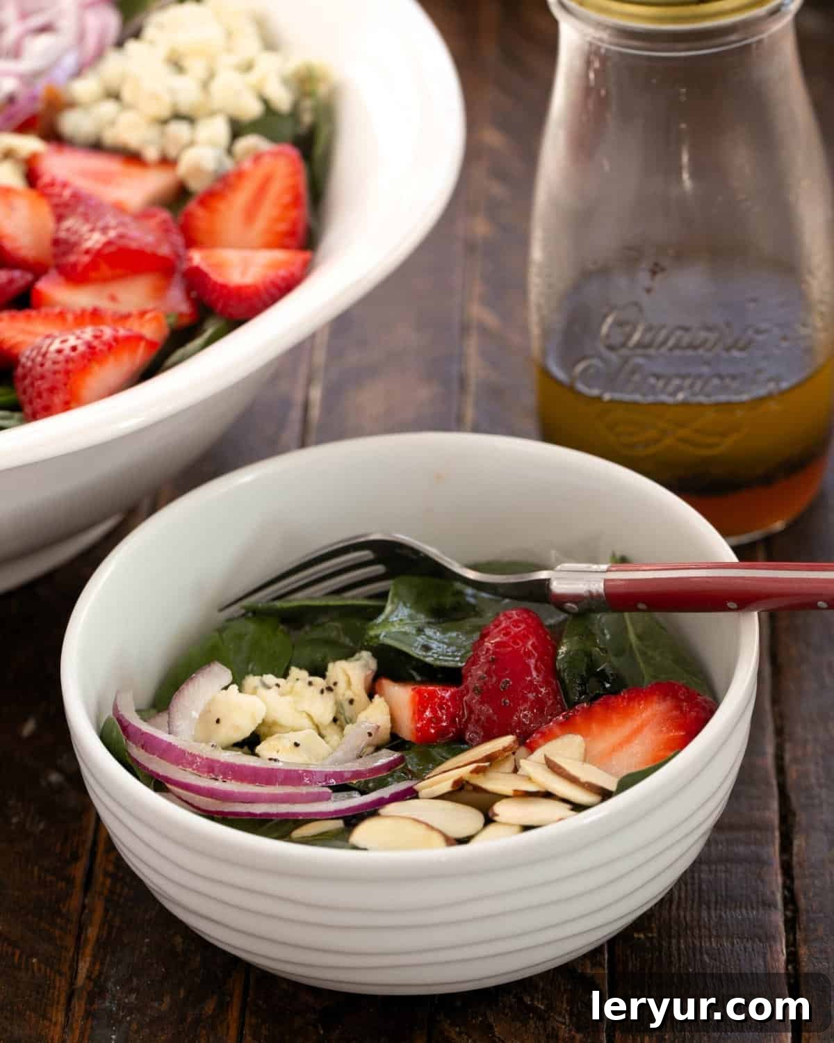 Vibrant Strawberry Spinach Salad with Tangy Blue Cheese 2 Small bowl filled with strawberry spinach salad in front of the serving bowl.