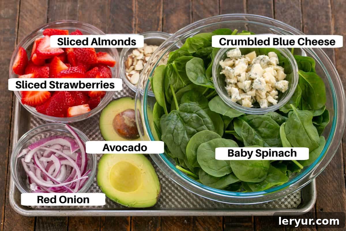 Vibrant Strawberry Spinach Salad with Tangy Blue Cheese 4 Spinach Salad with Strawberries and Blue Cheese ingredients with labels on a sheet pan.