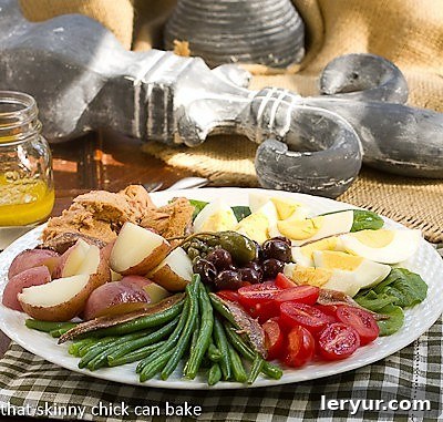 Classic French Salade Niçoise - Dorie Greenspan's delicious version of this classic French salad! Classic French Salade Niçoise side view on a white plate, highlighting the layering of ingredients.