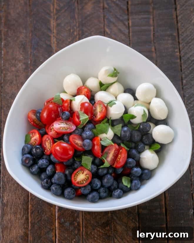 Berry-Kissed Caprese Salad 5 Salad ingredients ready to toss with dressing.