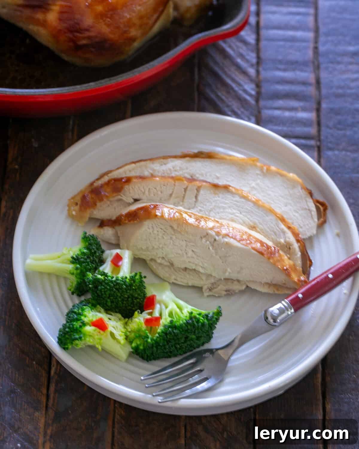 The Ultimate Buttermilk Chicken 2 Buttermilk chicken sliced on a plate in front of roasting pan.
