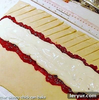 Detailed close-up of a Raspberry Danish Braid after baking, highlighting the perfectly sealed cuts and the rich filling visible through the braided top, showing off its golden crust.
