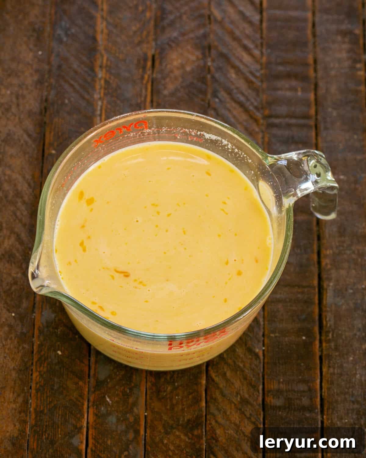 Beaten eggs, milk, dried mustard and salt mixed in a Pyrex measuring cup.