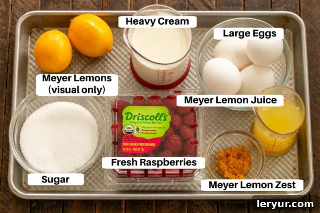 Key ingredients for Meyer Lemon Raspberry Mousse laid out on a sheet pan, including fresh Meyer lemons, vibrant raspberries, eggs, sugar, and heavy cream, all ready for preparation.