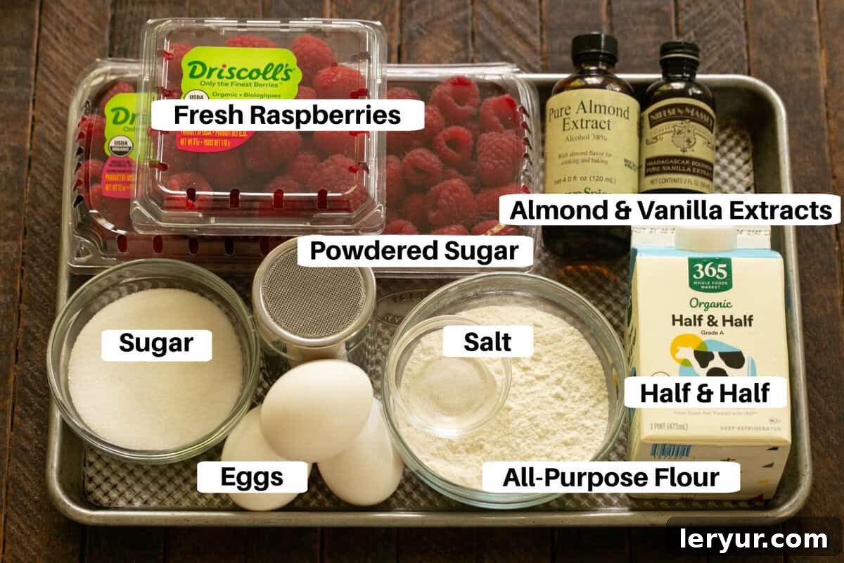 All the essential ingredients for Raspberry Clafoutis neatly arranged and labeled on a sheet pan, ready for preparation.